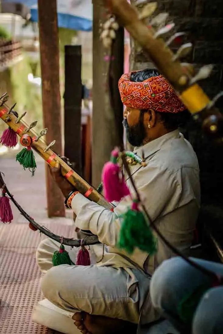 A street musician and his friend playing music in the streets of Shimla.