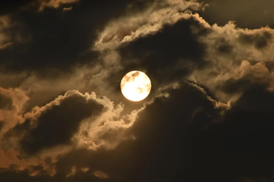 A cloudy evening photo of the sun before the eclipse of November 2022.